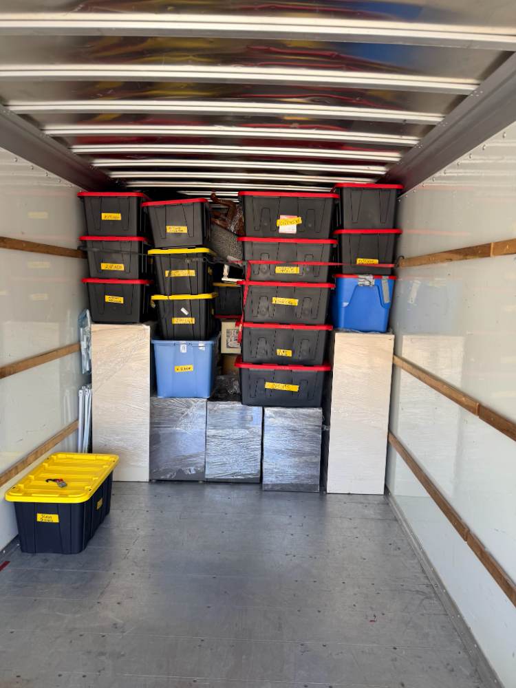 Washer, dryer, and stacked chairs padded and secured for transport