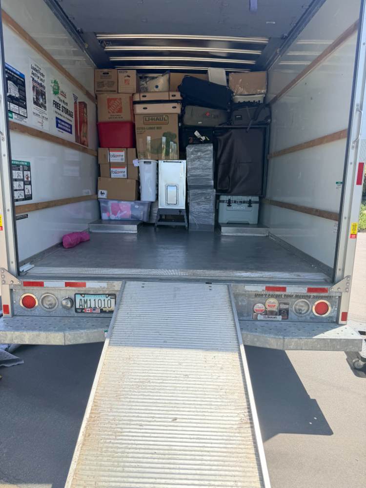 Kitchen totes labeled and strapped to the wall of the truck